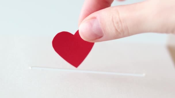 捐赠的概念 一个女人的手把她的心脏放在一个盒子的缝隙里 在特写中 — 图库视频影像