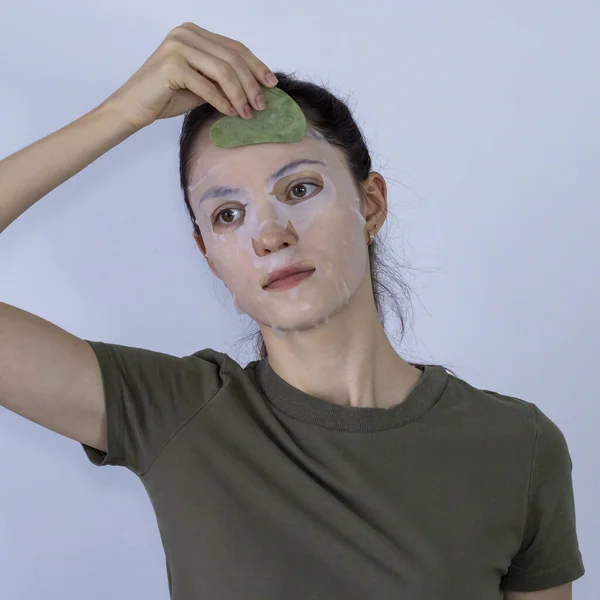 Genç Bir Kadın Guasha Maskesiyle Serumla Kendi Yüzüne Masaj Yapıyor — Stok fotoğraf