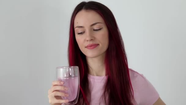 漂亮的年轻女子喝电解质 女孩在一个装有电解质和维生素的杯子里喝玫瑰水 排毒水 — 图库视频影像