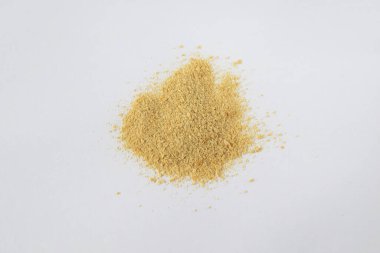 Non-activated nutritional yeast flakes are scattered on a white background clipart