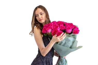 Siyah elbiseli, güzel, kıvırcık saçlı bir kadının portresi. Elinde bir buket gül, beyaz bir arka planda izole edilmiş..