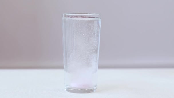 手は水のガラスに固定薬をスローします 水中およびスポーツ中に溶解ピンクの電解質を持つガラス — ストック動画