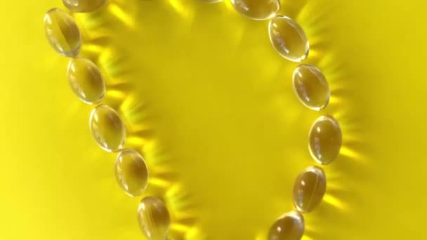 黄色の錠剤カプセル サプリメントビタニンD3を示す文字Dの形状を形成します オメガ3カプセル — ストック動画