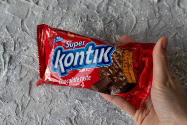 IRPEN, UKRAINE, 20 ARALIK 20222, Yuvarlak Süper Kontik çikolatalı kurabiyeler bir kadının elinde gri bir arkaplanda, Illustrative Editorial