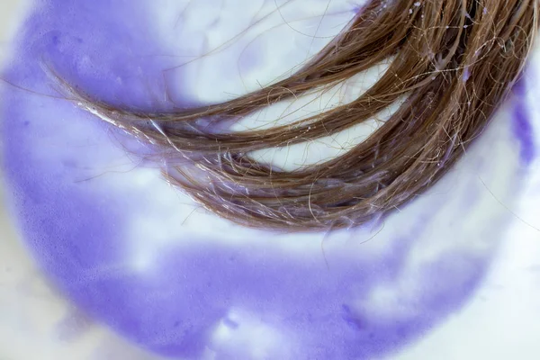 Purple mask on blond hair to remove yellowing and get a silvery shine in the hair