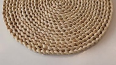 Round woven hyacinth mat carpet made from water hyacinth fibers for the kitchen on white background. Close-up of the flight along