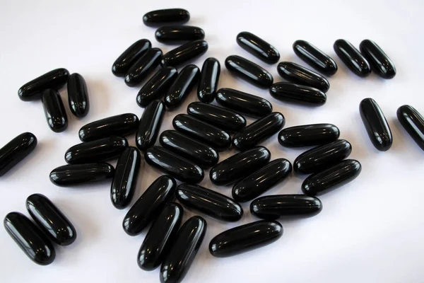 Black Activated Charcoal Capsules White Background Top View Treatment Digestive — Zdjęcie stockowe