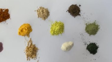 Sprinkled powder of tablets, vitamin and nutritional supplements. In turn: curcumin, vitamin C, ant tree bark, quercetin, q10, vegetable supplement, resveratrol, ginger, enzymes, spirulina. View from