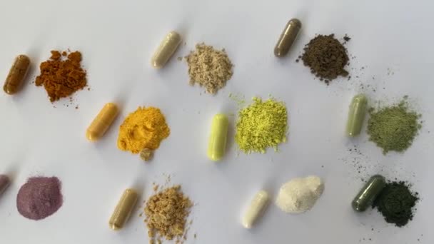 白の背景にサプリメントのオープンと全体のカプセル 様々な薬やビタミン 右上から左上 クルクミン ビタミンC アリの木の樹皮 ケルセチン Q10 野菜のサプリメント — ストック動画
