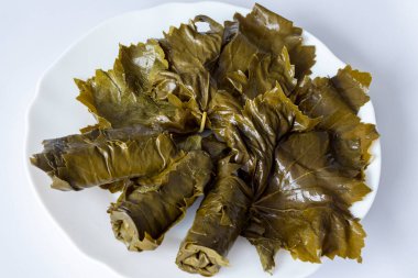 Pickled grape leaves in close-up. Grape leaves for traditional oriental dolma dishes and snacks on a white background.