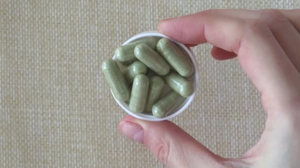 緑の健康サプリメントケール粉末錠剤 女性の手で健康な腸のための食物繊維プレバイオティクスサプリメント スペースのコピー — ストック動画