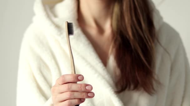 Hand Holding Bamboo Toothbrush Ecological Biodegradable Plastic Woman Beige Bathrobe — Vídeo de Stock