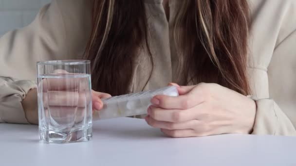 女性は薬を丸薬箱から注ぎ 水を飲みます 隣の女性の手に医学の容器 薬や薬の投与量とリマインダーの概念 — ストック動画