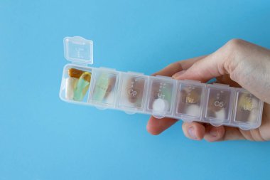 Pill box. Medicine container in the hands of a woman.