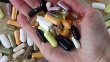Curing diseases with pills and supplements. Lots of colorful pills in a womans hand. The concept of pill abuse. Treatment for Health