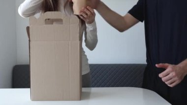 Unpacking a weeks worth of food. A woman and a man are unpacking boxes of groceries