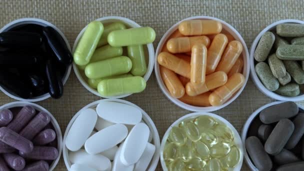 中央に薬でベージュの背景 丸い帽子の様々な薬や薬 最上階だ ビタミンD 活性炭 クルクミン Coq10 マルチビタミンカプセル — ストック動画