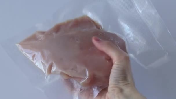 鶏の胸肉を真空 女性の手で白い背景に切り身 そのような側面で沸騰させる準備 — ストック動画