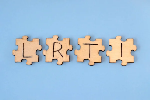 Lower Respiratory Tract Infections - LRTI. Lettering on wooden puzzles on a blue background.