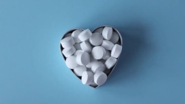 Beyaz yuvarlak tabletler, mavi arka planda takviyeler. Magnezyum vitaminleri.