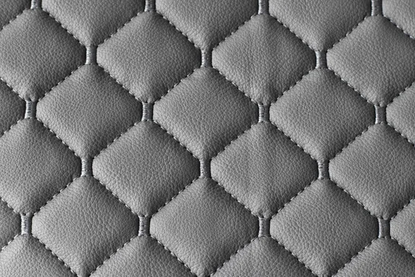 Leather gray fabric quilted, stitched with synthetics. Fabric for furniture upholstery. Close-up