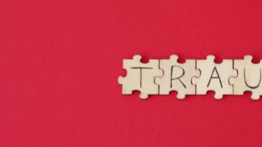 The word TRAUMA written on the puzzles on a red background.