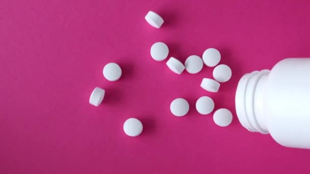 Okrągłe Białe Tabletki Wyciekają Słoika Tabletkami Różowym Tle — Wideo stockowe