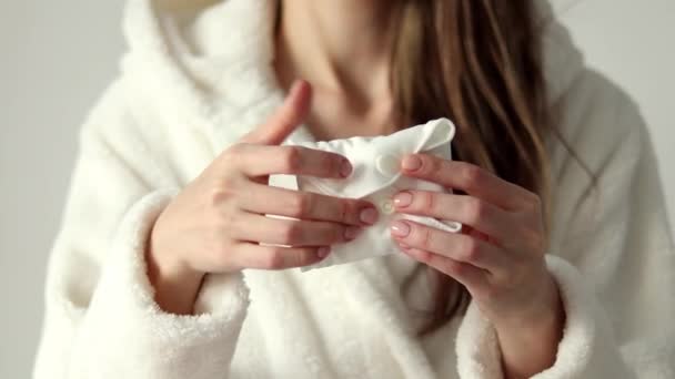 Woman Unwraps White Reusable Pad — Vídeo de Stock