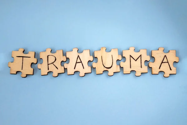 TRAUMA sözcüğü mavi arka plandaki bulmacaların üzerine yazılmış..