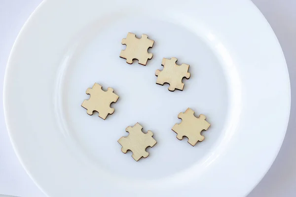 A mock up of five wooden puzzles on a plate. 5 blank spaces for inscription