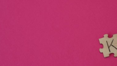 Keto of wooden puzzles. Inscription on a bright pink background.