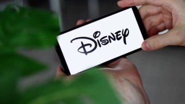 IRPEN, UKRAINE - 20 HAZİRAN 20223, Akıllı Telefon Ekranı Walt Disney Şirketi logosu Erkek Ellerinde, Illustrative Editorial