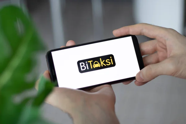 Stock image IRPEN, UKRAINE - JANUARY 20 20223, Closeup of smartphone screen BiTaksi logo lettering with in mans hands, Illustrative Editorial