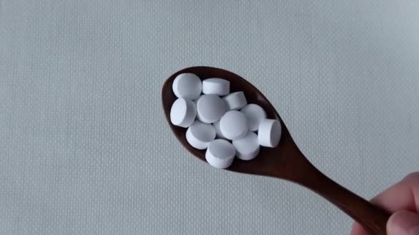 White Pills Supplements Wooden Spoon Beige Background Womans Hand — стоковое видео