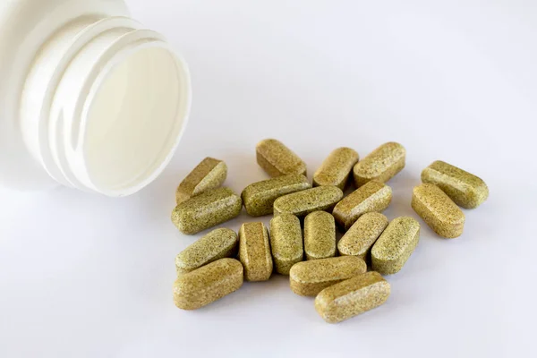 Brokoli sülforafhane vitamini beyaz arka planda kapsüllerde, yalancı takviye kavanozunun yanında. İlaçlar ve ilaçlar..