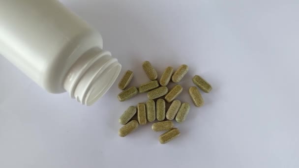 西兰花黄花素维生素在白色背景的胶囊中 旁边躺着一罐的补充剂 药丸和药物 — 图库视频影像