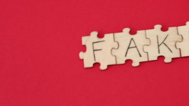 Word Fake Assembled Wooden Puzzles Handwritten Words Red Background — Stock Video