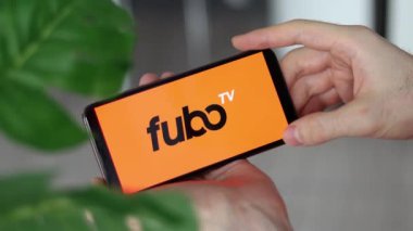 IRPEN, UKRAINE - JANUARY 20 20223, Closeup of smartphone screen Fubo TV logo lettering with in mans hands, Illustrative Editorial