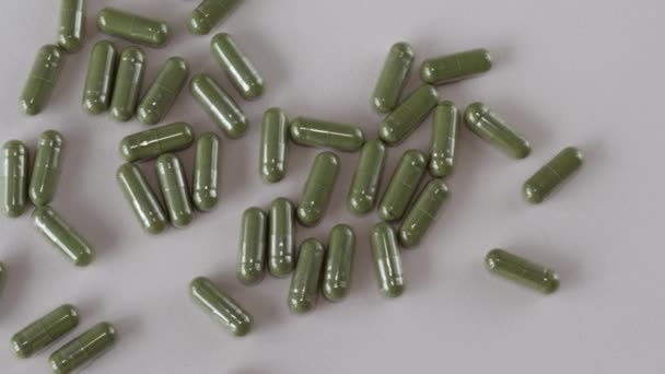 许多亮绿色的药片散布在米黄色的背景上 从上面看 — 图库视频影像