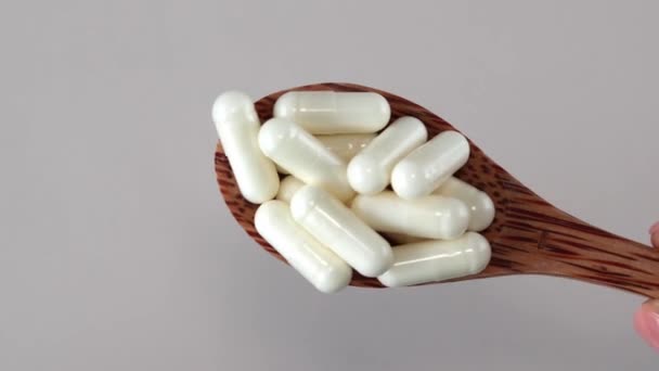 Cápsulas Blancas Vitamina Una Cuchara Madera Sobre Fondo Beige Primer — Vídeos de Stock