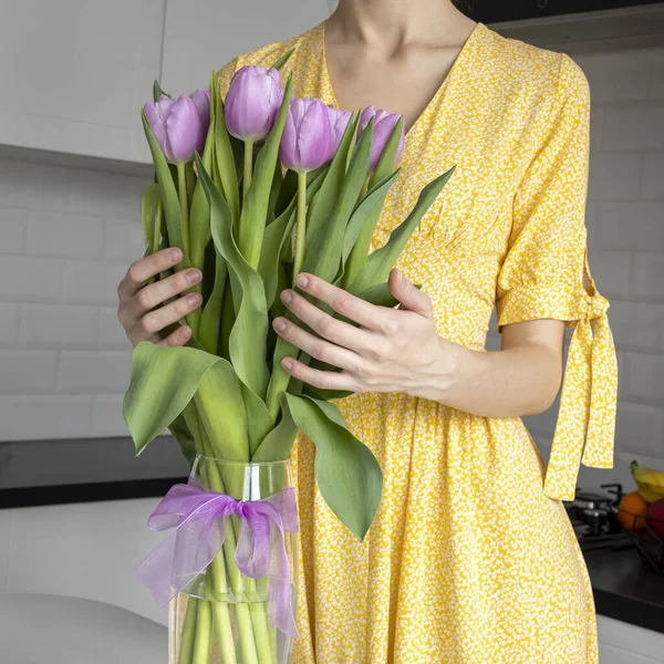 Csokor Lila Tulipán Egy Átlátszó Váza Hátterében Egy Fehér Ruhában — Stock Fotó