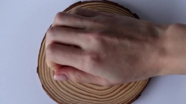 Ahşap arka planda beyaz kapsül enzim takviyeleri. Bir kadın eli, beyaz ilaçları kürsüye koyar.