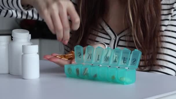 Gesundheitsalltag Eine Frau Verteilt Orangefarbene Kapseln Mit Nahrungsergänzungsmitteln Einem Pillenregal — Stockvideo
