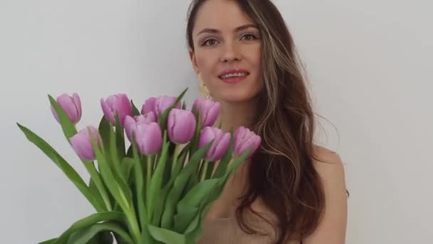 Schöne Glückliche Junge Frau Lächelt Mit Einem Strauß Pinkfarbener Tulpenblüten — Stockvideo