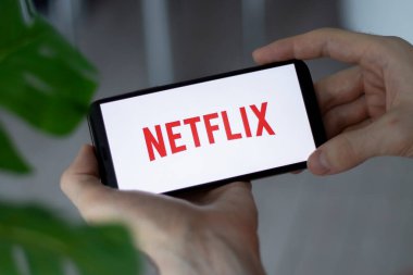IRPEN, UKRAINE - 20 HAZİRAN 20223, akıllı telefon ekranı Netflix logosunun kapanışı erkeklerin elinde, Illustrative Editorial