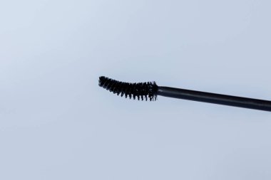 Beyaz arkaplanda siyah Mascara fırçası, yakın plan.