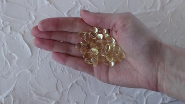 透明な黄色のビタミンD3サプリメントカプセル女性の手で クローズアップ 健康と健康 自己薬 — ストック動画