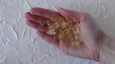 Omega 3 'lü büyük sarı kapsüller ya da bir kadının elinde balık yağı, yakın plan. Sağlık ve sağlık, kendi kendine tedavi.