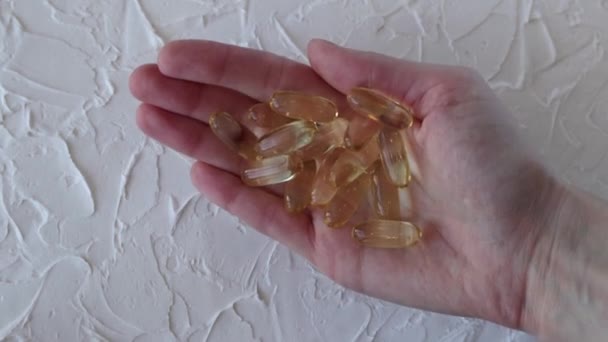 Cápsulas Amarelas Grandes Com Omega Óleo Peixe Uma Mão Mulher — Vídeo de Stock