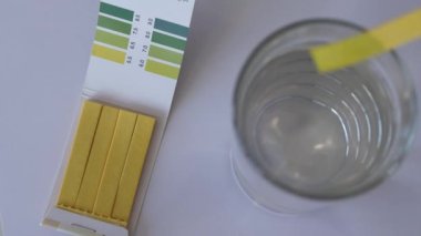 Suyun pH 'ını test şeritleriyle ölçmek.